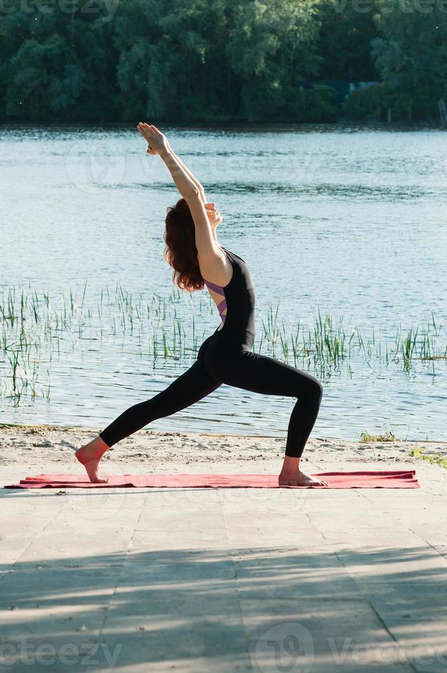 Ajuste la práctica femenina del ejercicio de yoga al aire libre foto