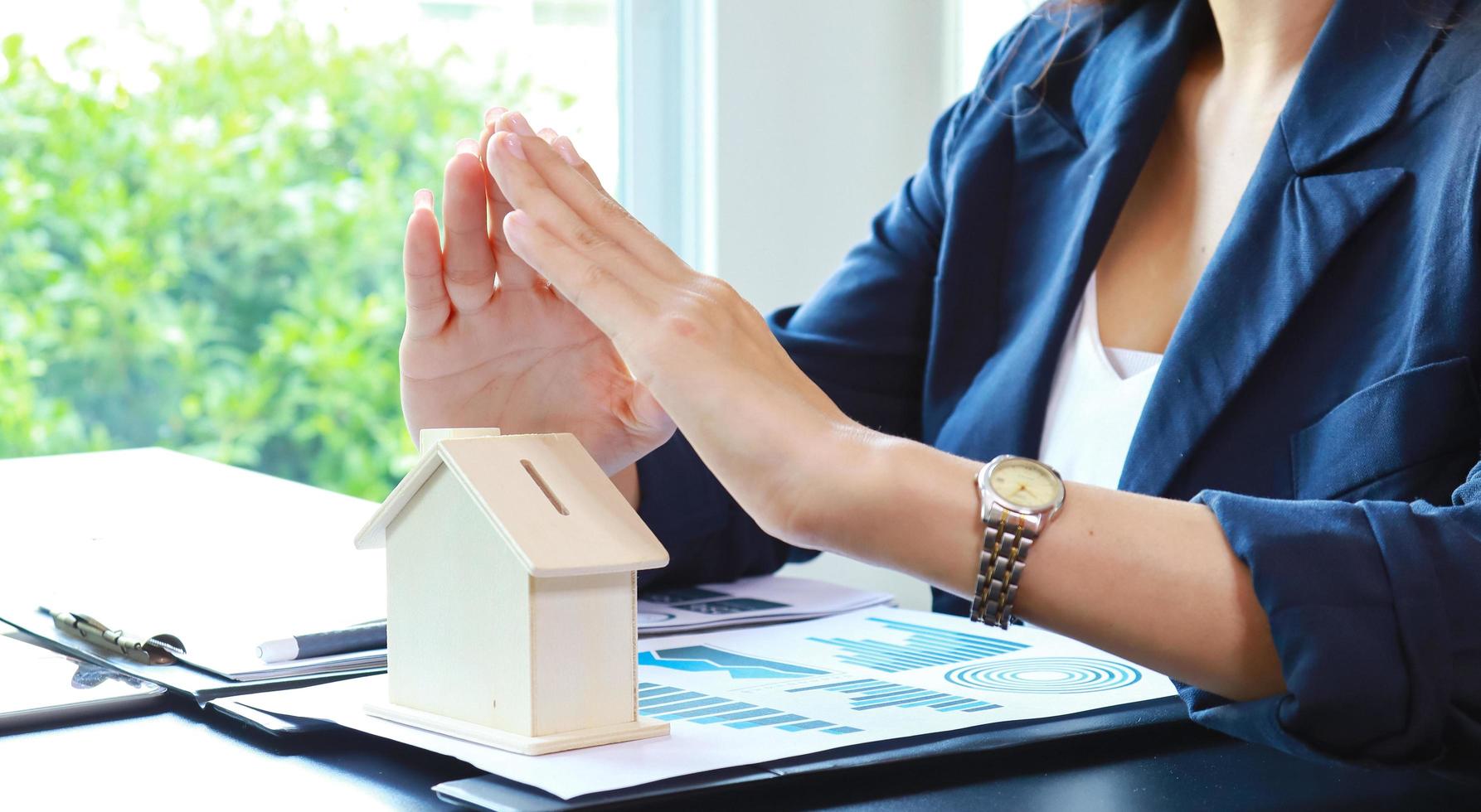 Close up hand of woman holding model house Concept of buying house photo