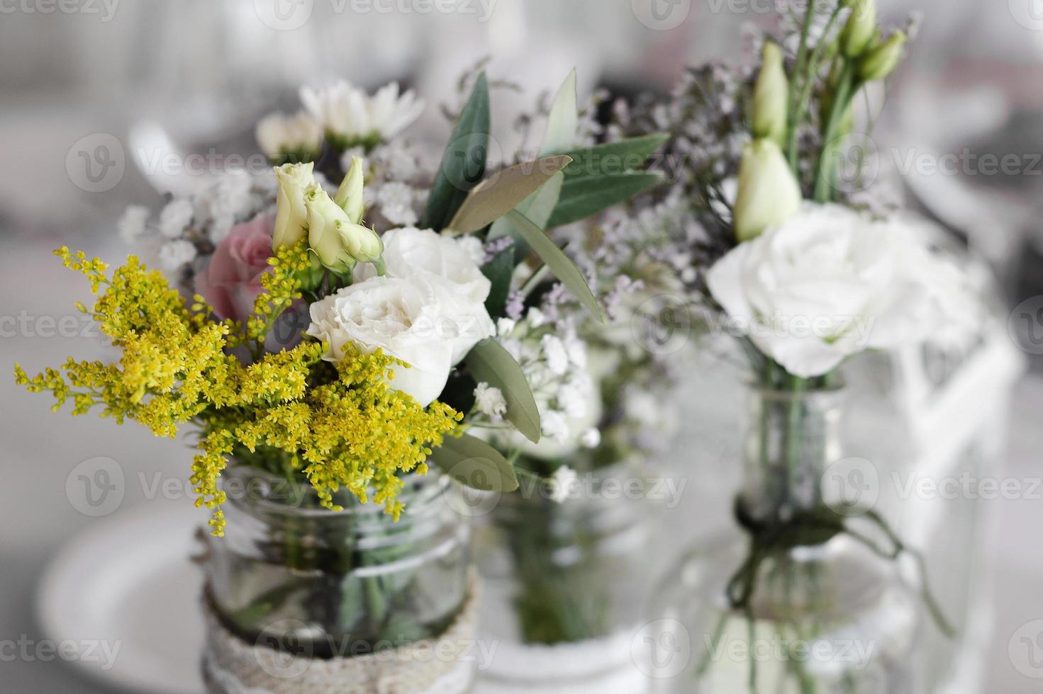 Arreglo de flores y decoración de diseño interior rústico en mesa de boda foto