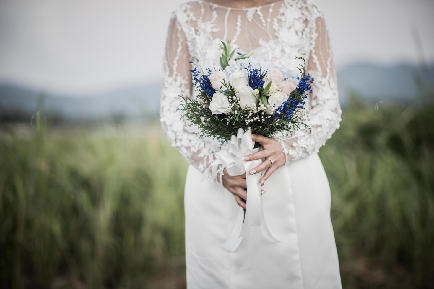 mano de la novia sosteniendo la flor en el día de la boda foto