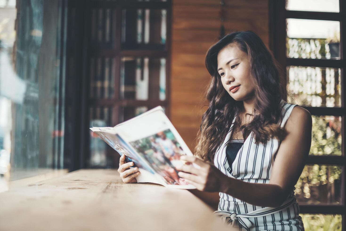 Beautiful woman reading magazine in cafe photo