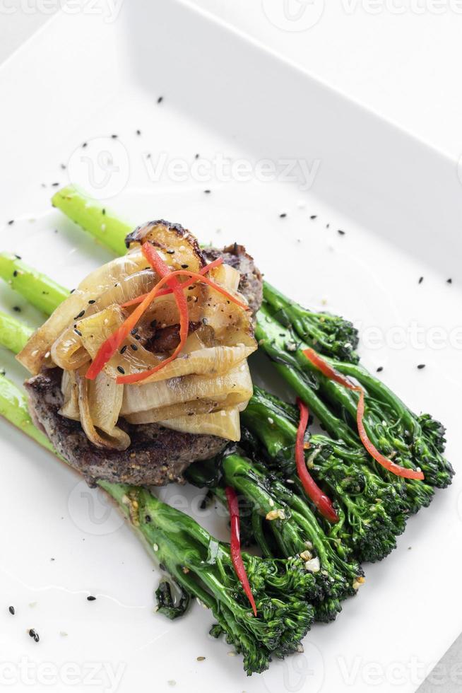 bistec de ternera con cebolla caramelizada y brócoli comida de restaurante gourmet foto