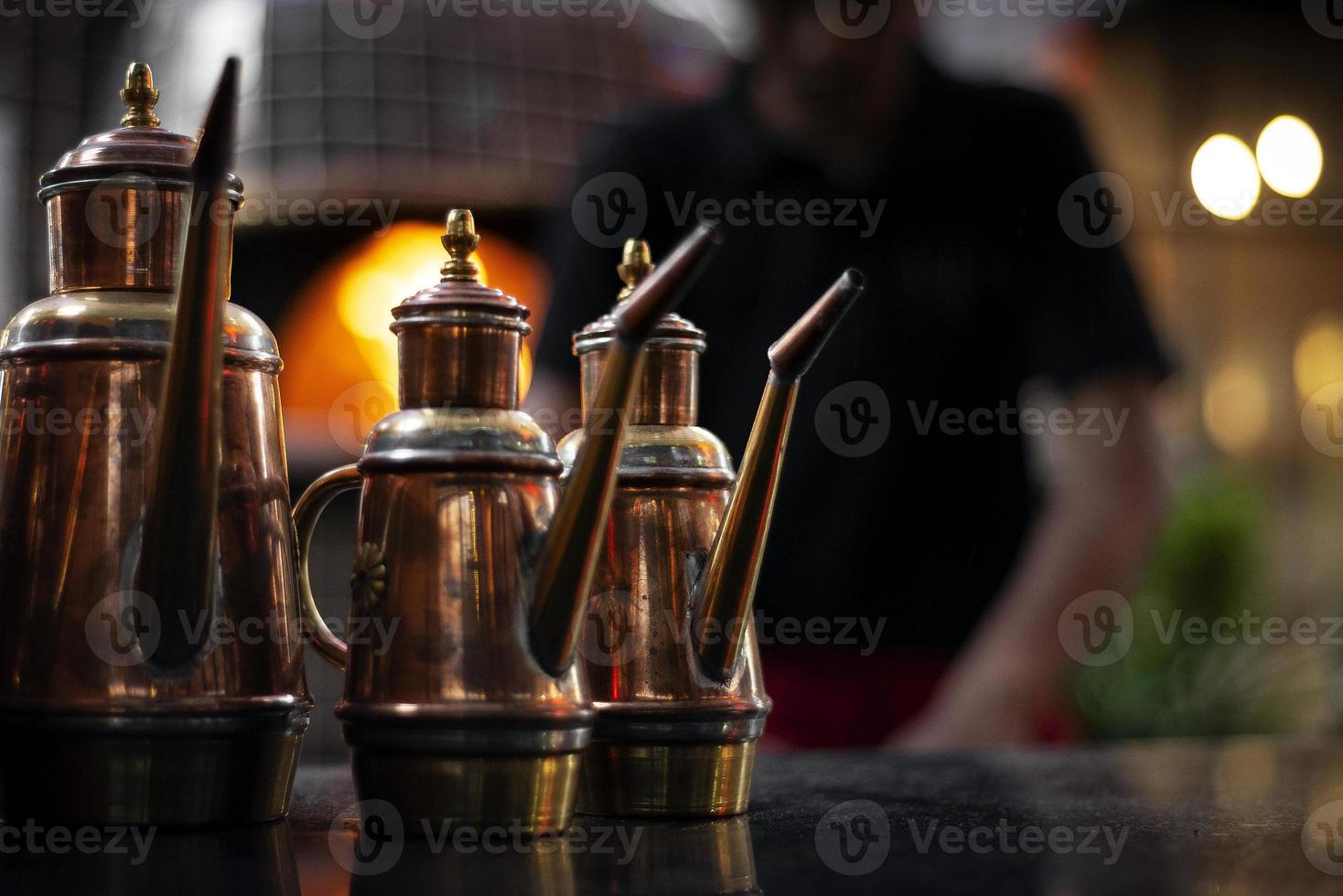 Vinagrera de cobre de aceite de oliva tradicional detalle dispensador en restaurante italiano foto