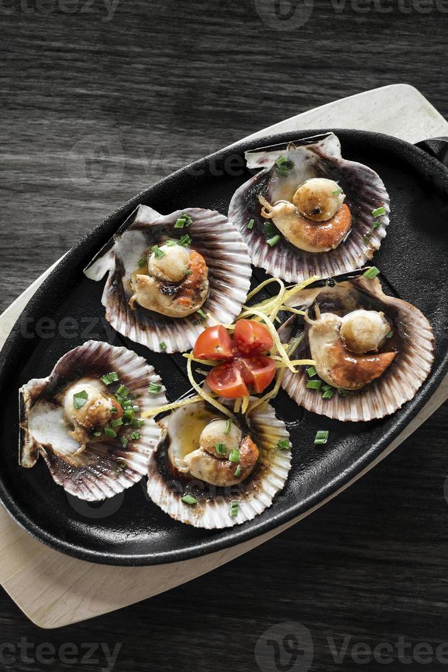 Vieiras con cáscara de mariscos porción de tapas en el restaurante de Barcelona España foto