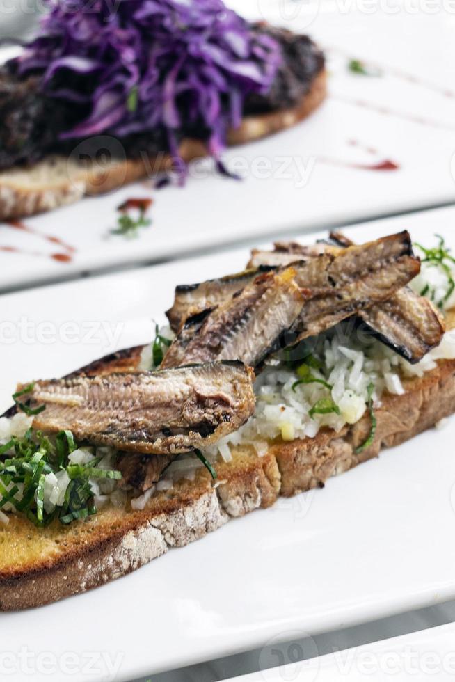 Portuguese tiborna open toast sandwich tapas with sardine and onion garlic photo