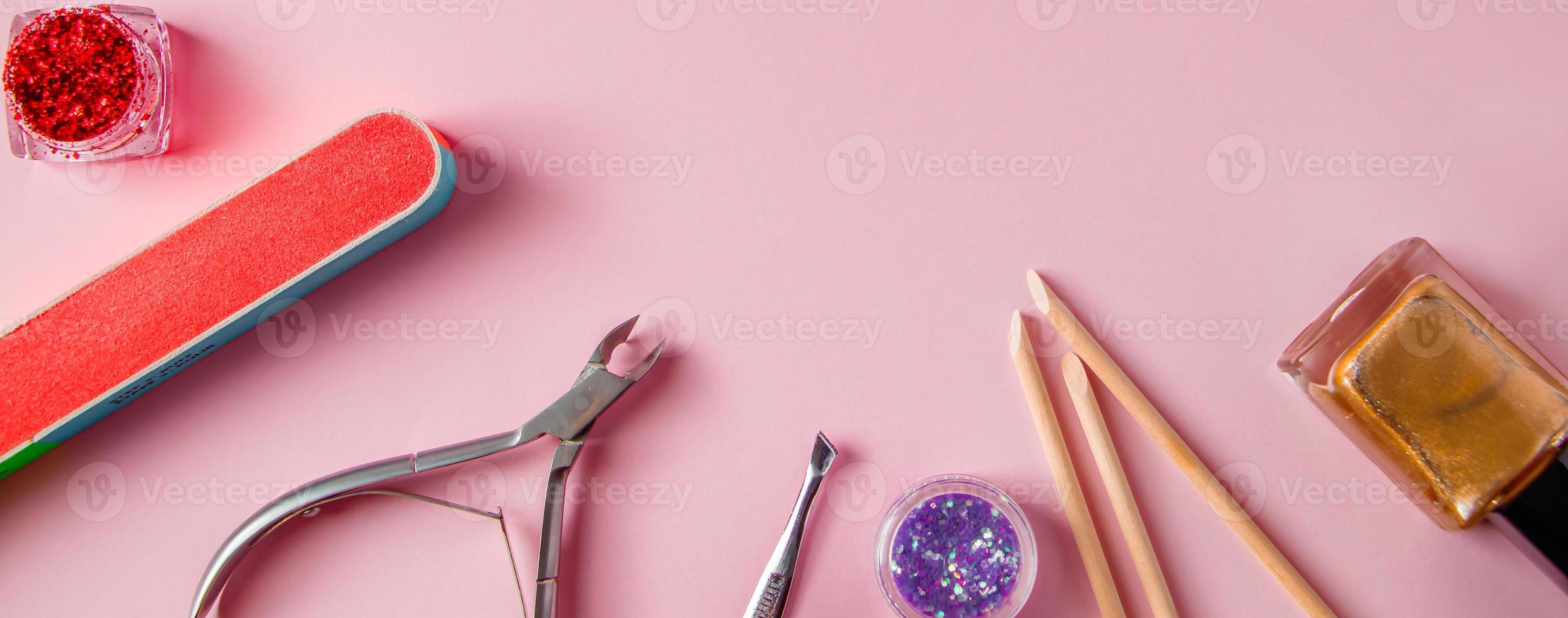 A set of tools for manicure and nail care on pink background. Workplace in a beauty salon. Place for text. photo