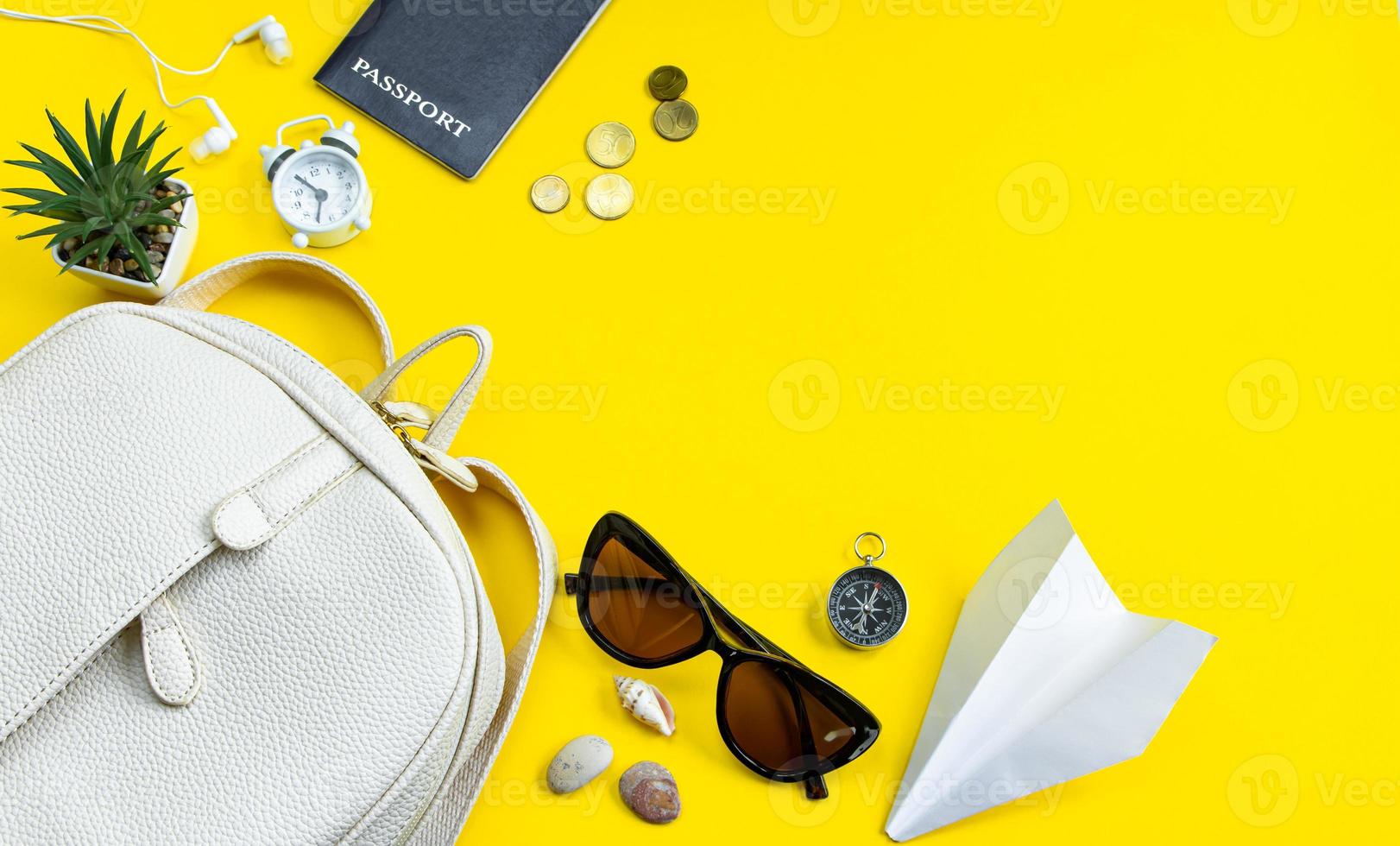 concepto de viaje de verano. accesorios de viajero. pasaporte, dinero, gafas de sol sobre un fondo amarillo. flatlay. foto