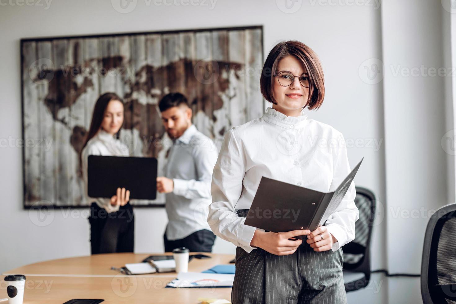 Serious, attractive girl in glasses works in the office. Working atmosphere concept photo