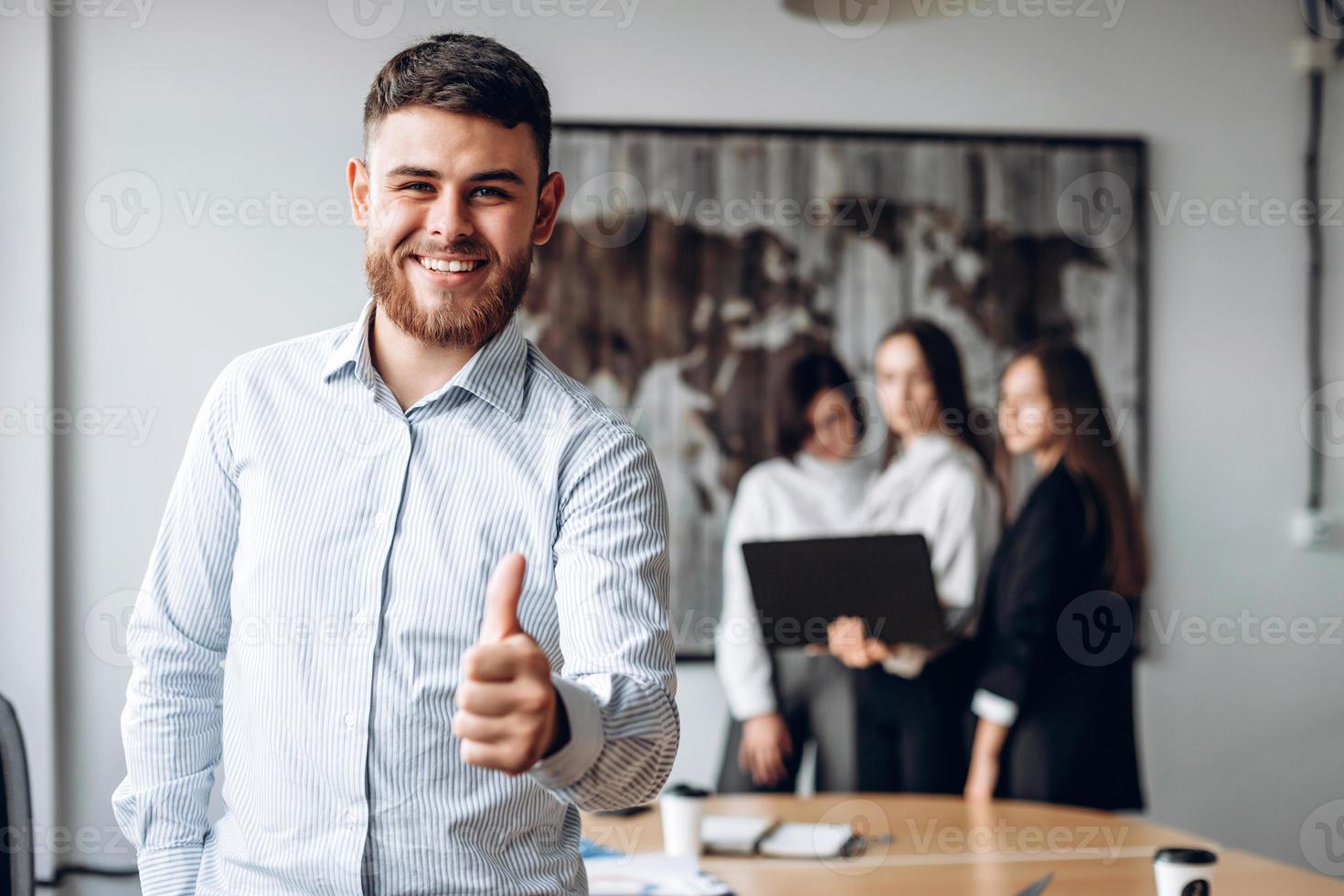 hombre exitoso y feliz con barba muestra el pulgar hacia arriba. foto