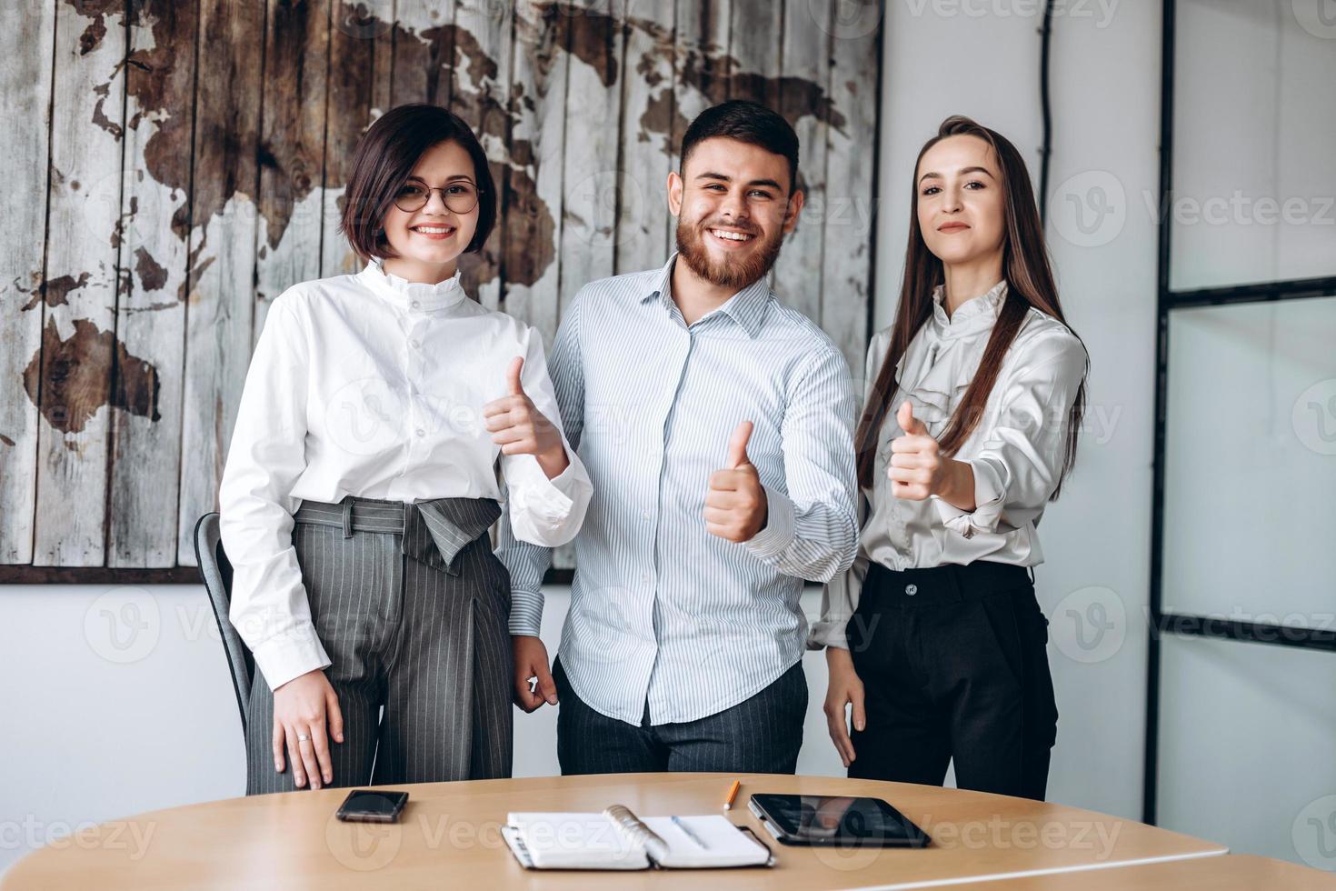 Young team of three showing showing thumb up photo