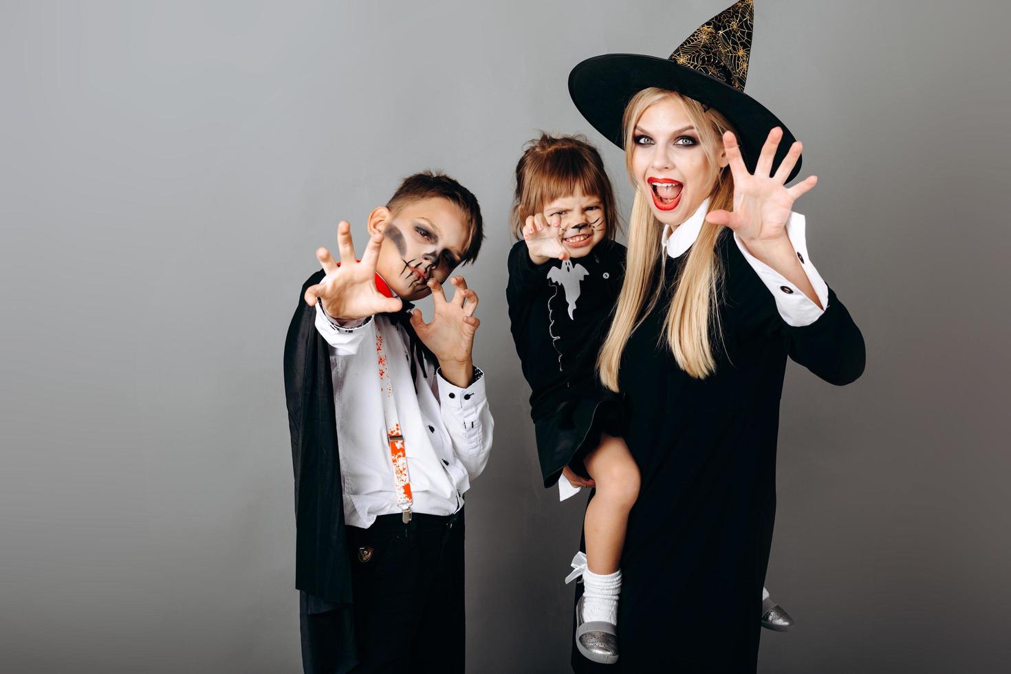 Family in fancy dress showing scary gesture looking at the camera.- Image photo