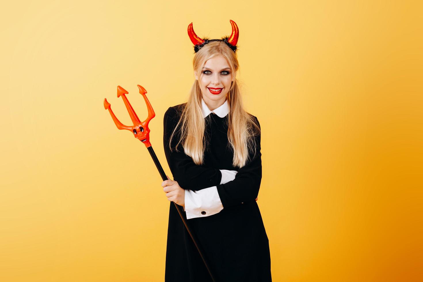 devil woman standing against a yellow background photo