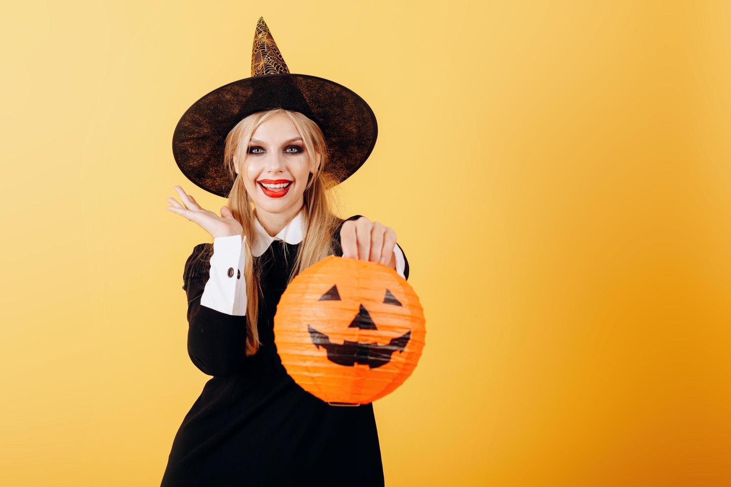 felizmente la emoción de la mujer de pie sobre un fondo amarillo con calabaza. - imagen foto