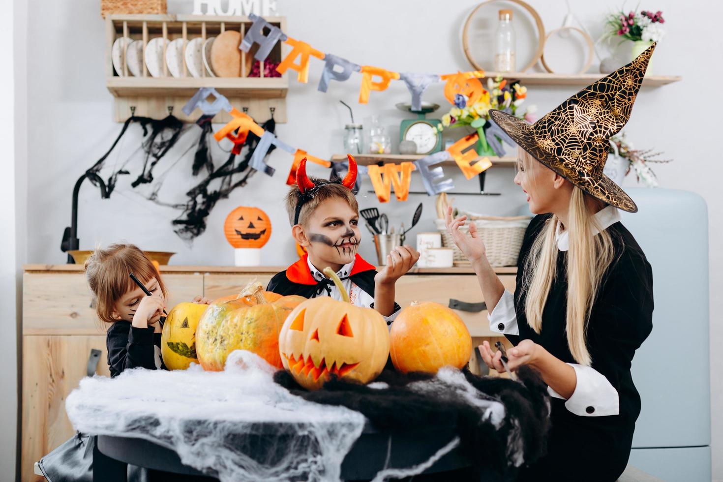 Mother and children are talking and have funny time at home. -Halloween concept photo