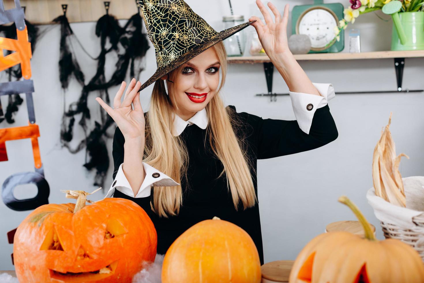Portrait of happy woman touches her hat and  playfully looking at the camera.- Image of Halloween photo