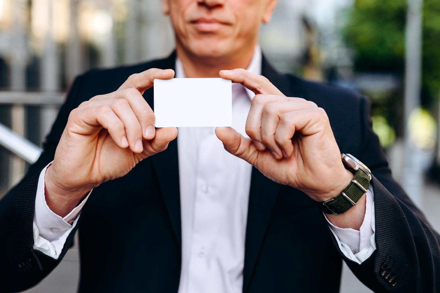 Primer plano blanco vacío maqueta en blanco de tarjeta de visita en manos masculinas - espacio de copia foto