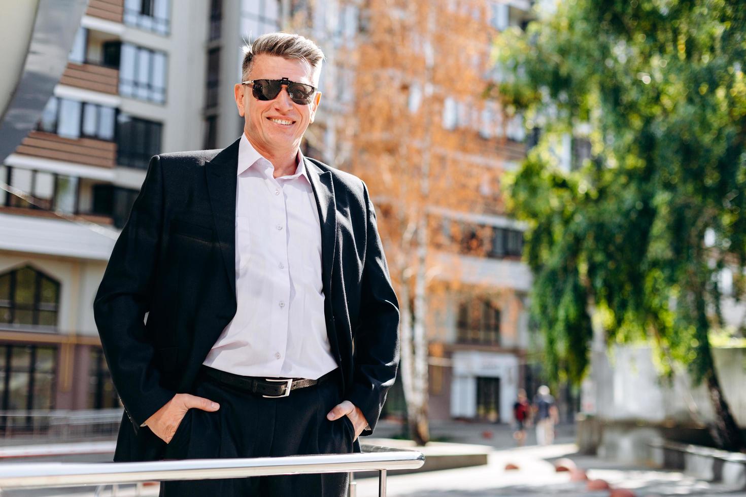 apuesto hombre de negocios sonriendo de pie en la calle al aire libre. - imagen foto