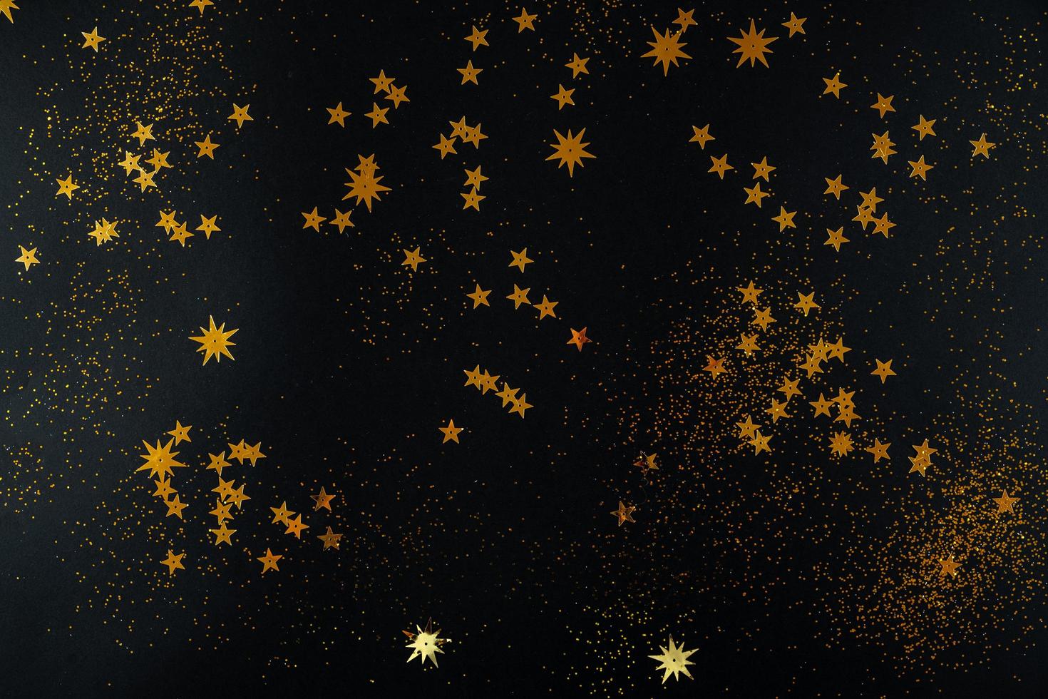 estrellas doradas sobre fondo negro. endecha plana, vista superior. foto