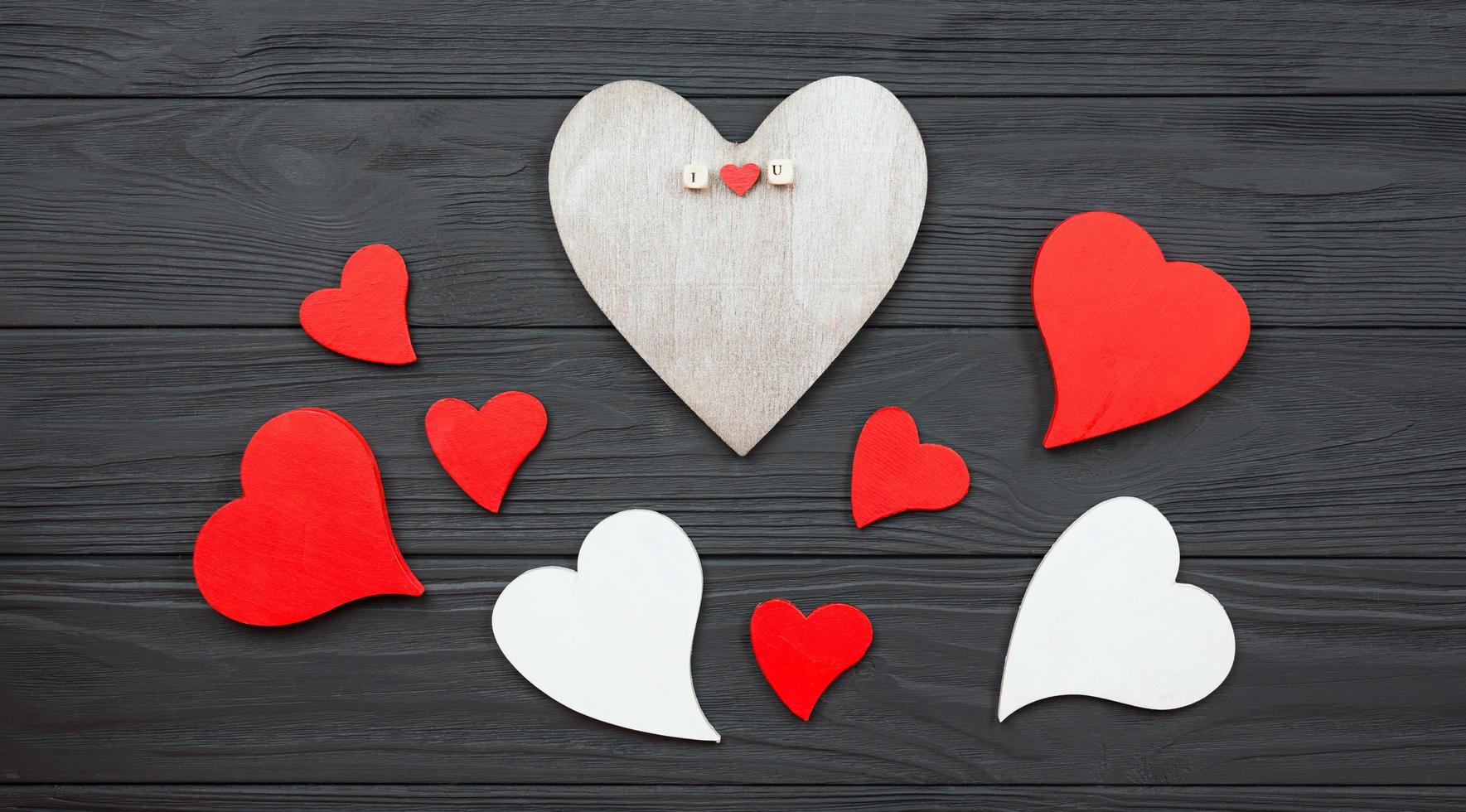 Hearts are laid out on a dark wooden background. photo
