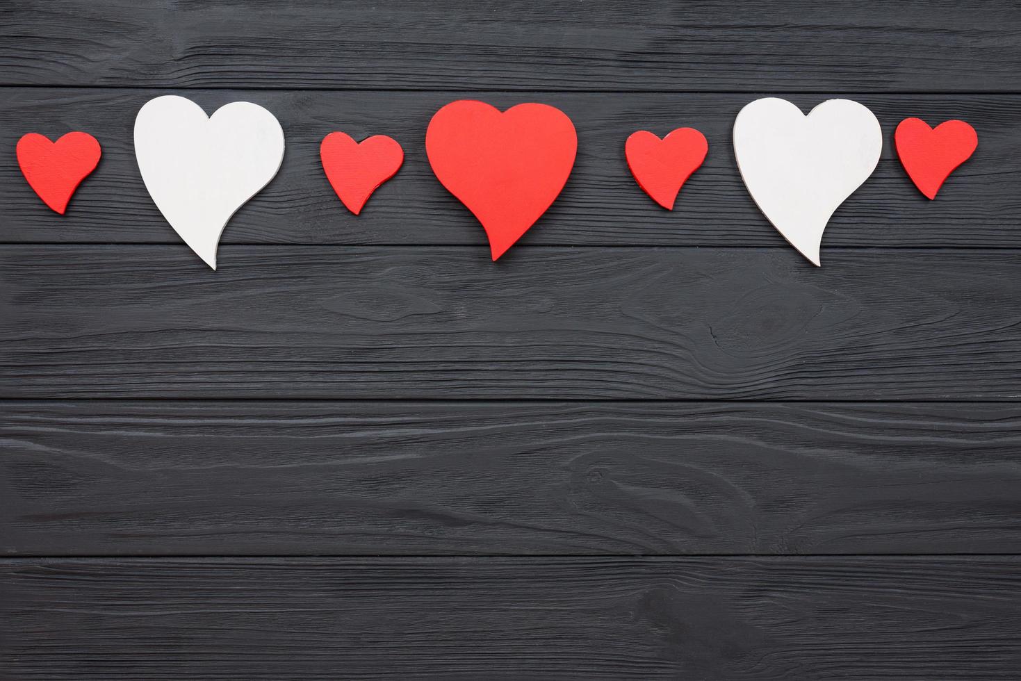 Red and white hearts on dark wooden background. photo