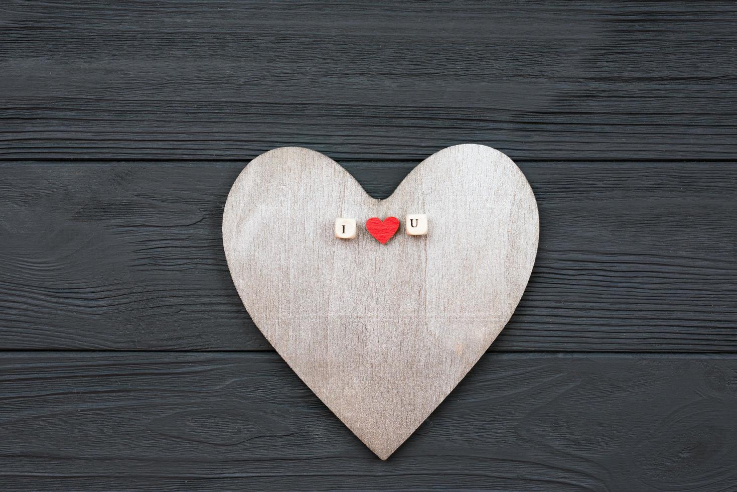 corazón de madera se encuentra sobre fondo de madera. concepto de eventos de amor, día de san valentín foto