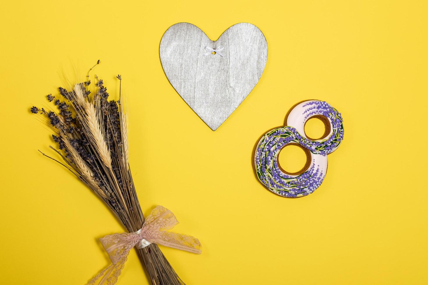 figure eight and heart, a bunch of dry grass lie  on a yellow background photo