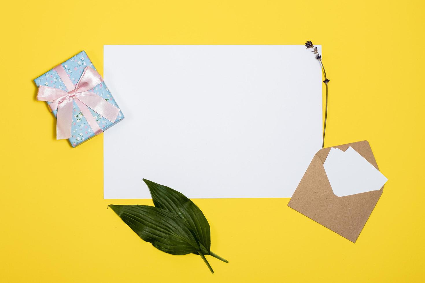 white sheets, envelope, gift box  lie  on a yellow background photo