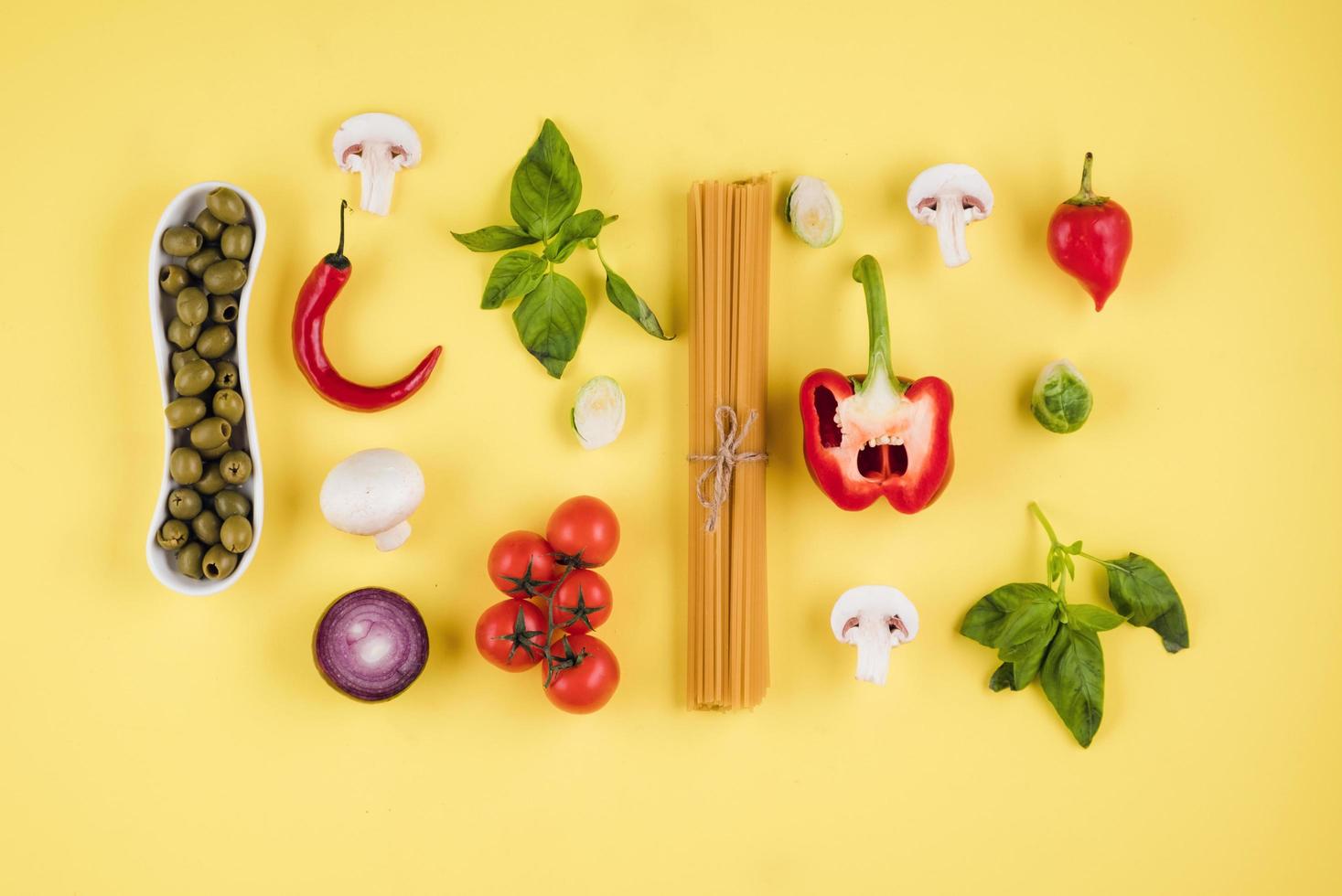 Set of pasta products on yellow background, top view. photo