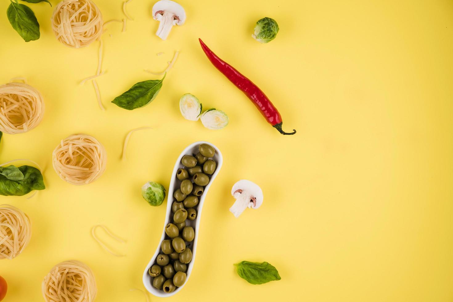 Pasta, basil, olives. Background of products. Top view. Copy space on the right. photo