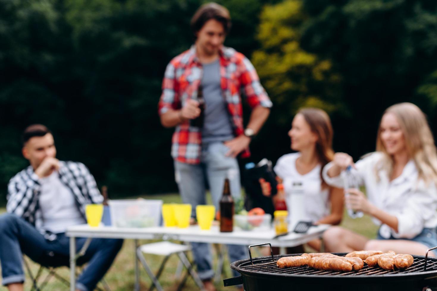 salchichas de cerca en la barbacoa en el foco. fondo borroso foto