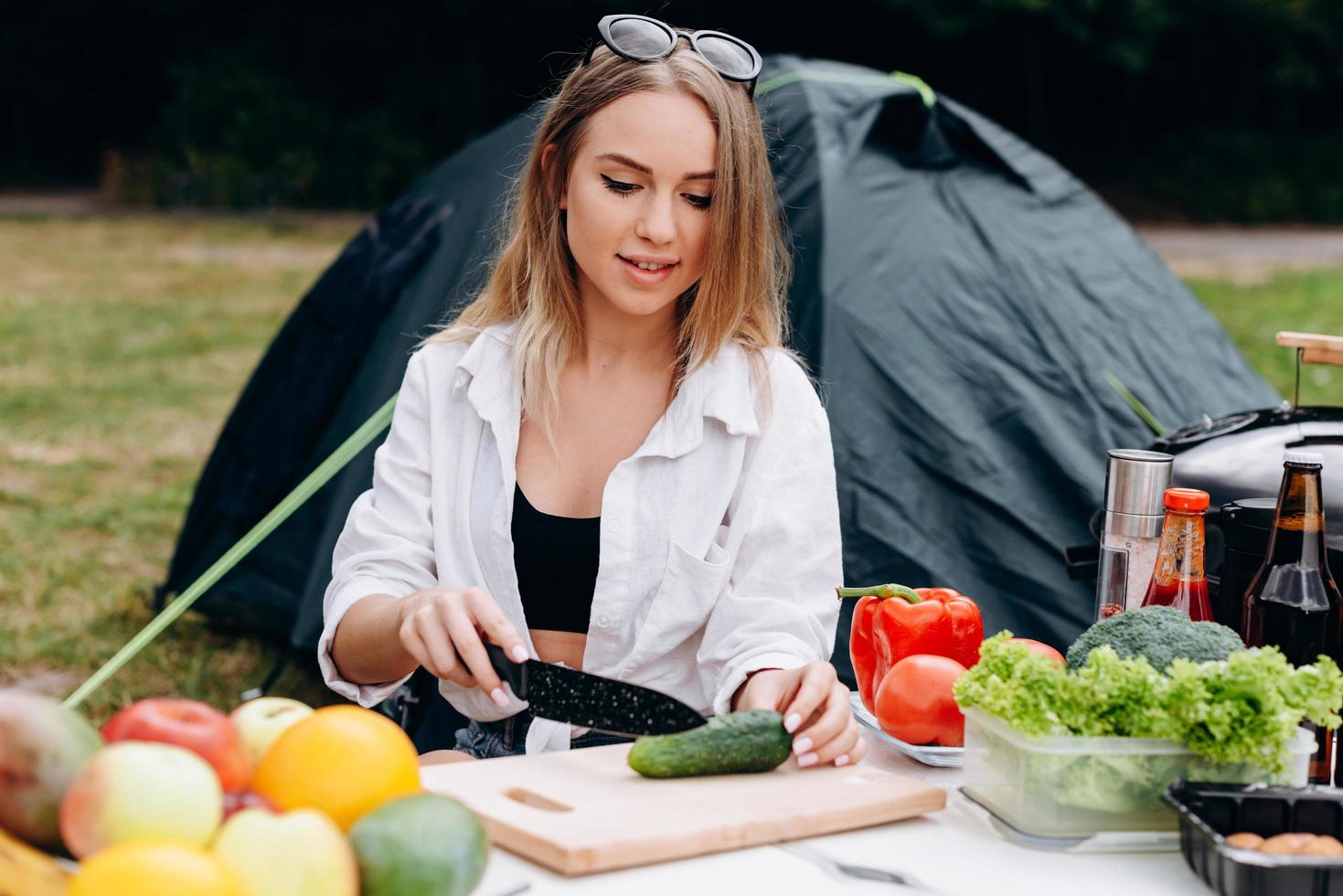 mujer preparando comida al aire libre en el camping foto