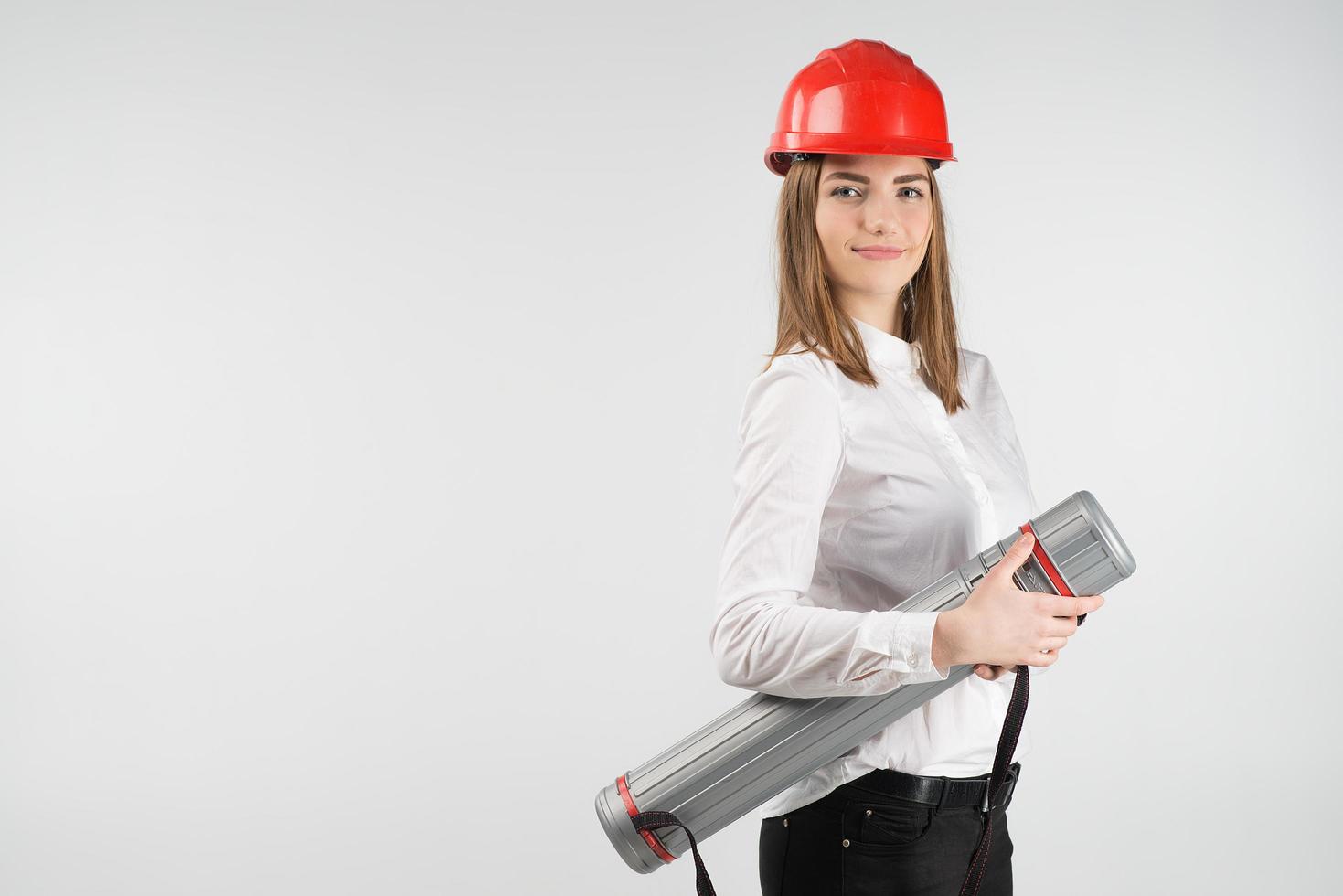 Smiling woman  stands  in orange helmet holds tube. - Place for text photo