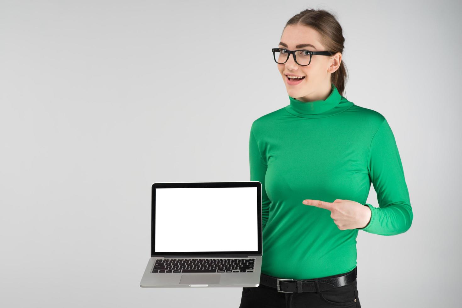 Happy girl holds a laptop and pointing to a screen. -- Image photo