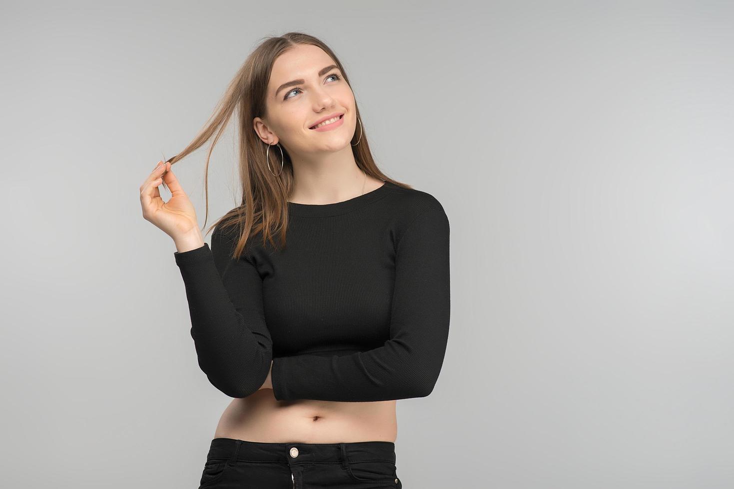 Photo of dreamy smiling blonde girl posing in black  top. - Image