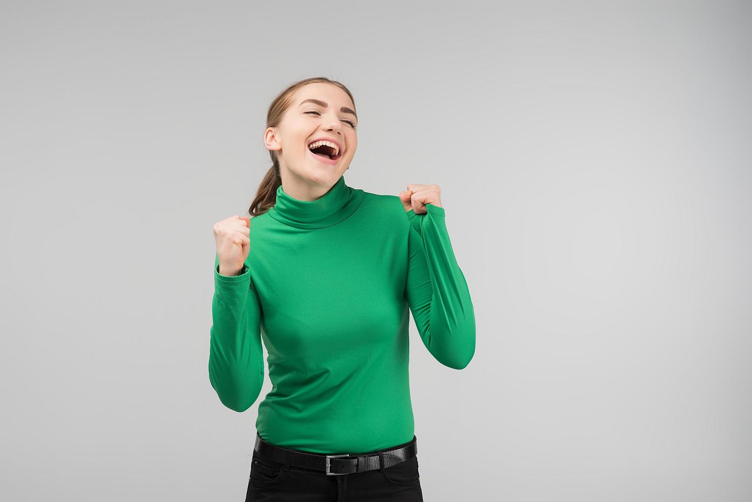 young woman is very happy standing in the studio. Emotions of joy photo