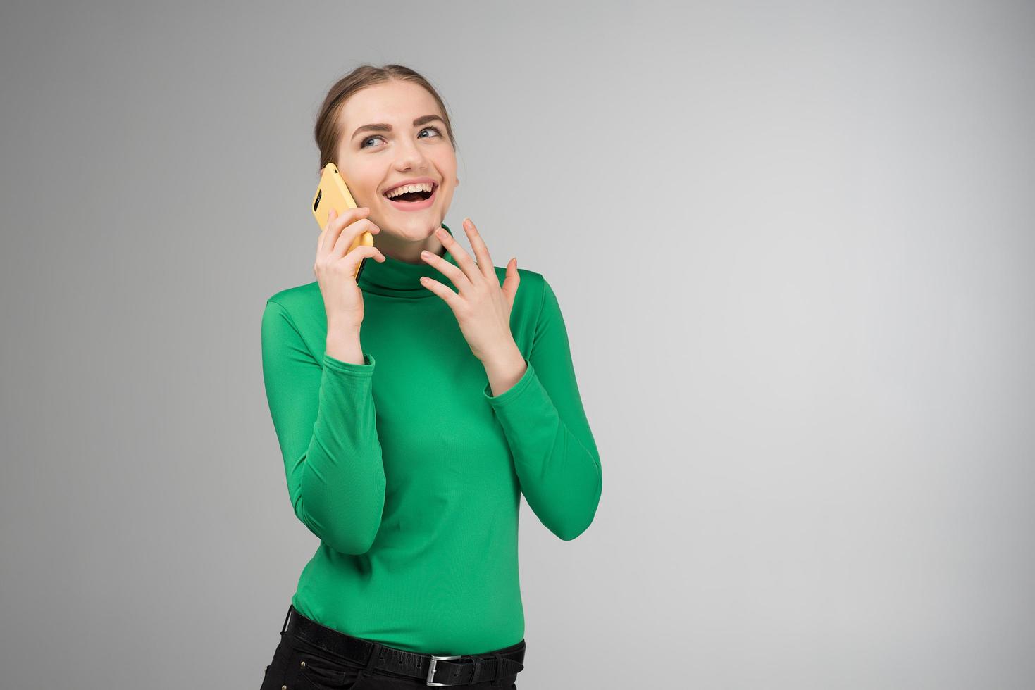 Joyful young woman talking on a cell phone and laughing photo