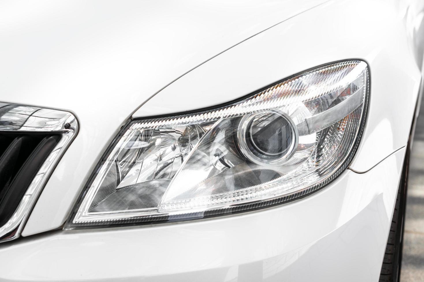 Modern and elegant white car - Closeup of car headlight photo