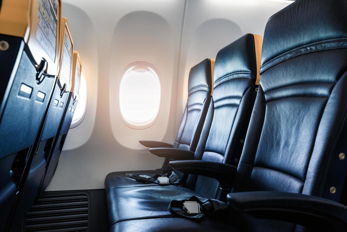 Plane interior - cabin with modern leather chair for passenger of airplane. Aircraft seats and window. - Horizontal image photo