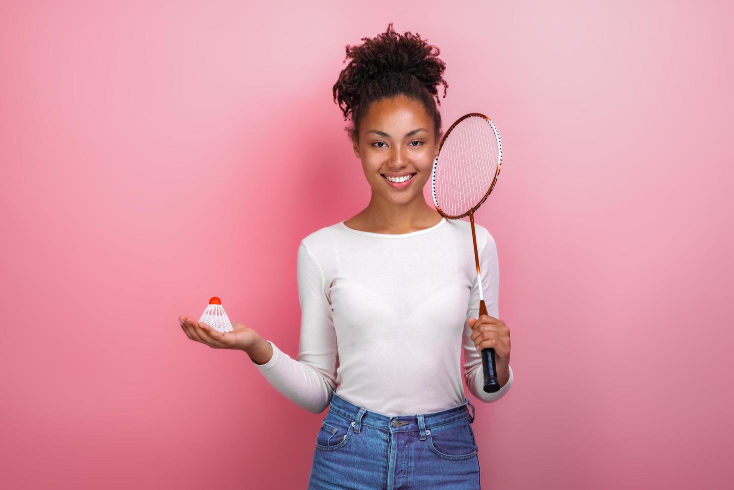Pretty girl standing with badminton accessories in the studio looking at the camera photo
