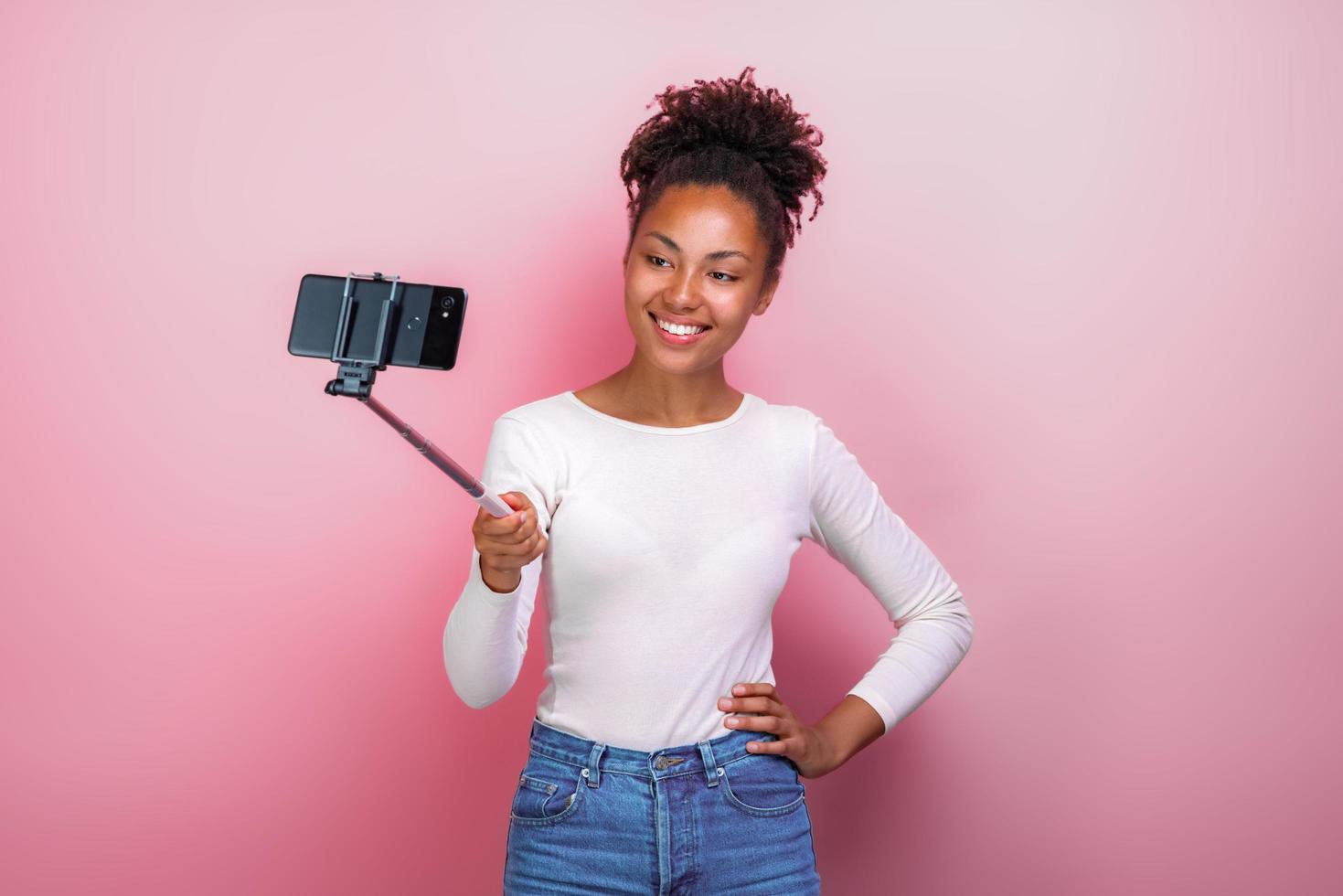 Young girl holding mobile phone takes a picture selfie - Image photo
