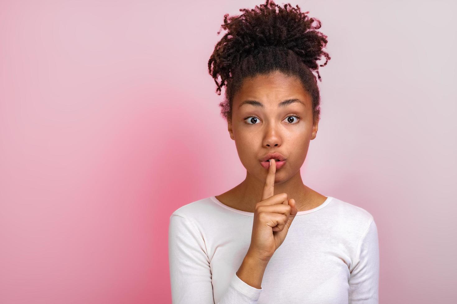 linda mujer muestra un gesto de silencio tocando con el dedo índice sus labios. gesto de concepto - imagen foto