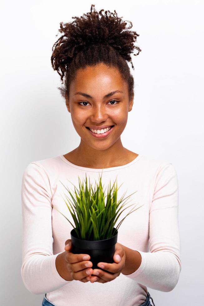 Girl with grass pot in her hands which she holds in a straight arms .Concept World Environment Day photo