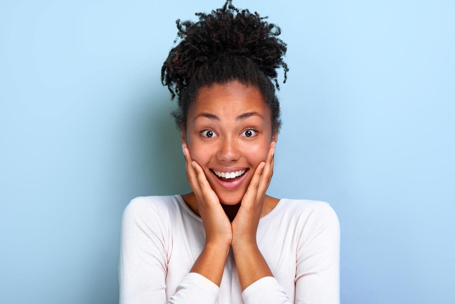 Closeup portrait of a pretty girl over blue background with amazed emotion on face - Image photo