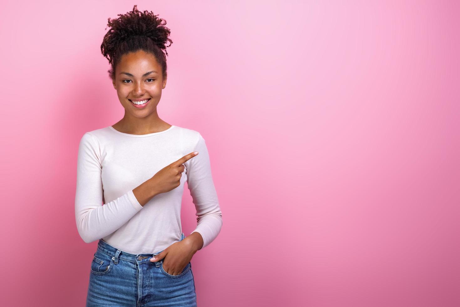 Studio portrait of a happy girl pointing sideways for empty place- Image photo