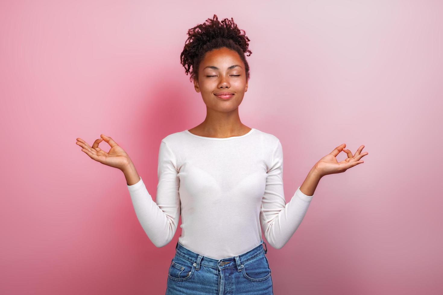 Pretty girl standing arms apart in the maditation gesture with closed eyes.- Image photo
