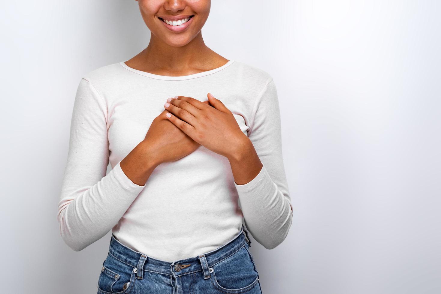 Cropping image of cute woman shows a love gently gesture with her arms on her chest. Concept gesture photo