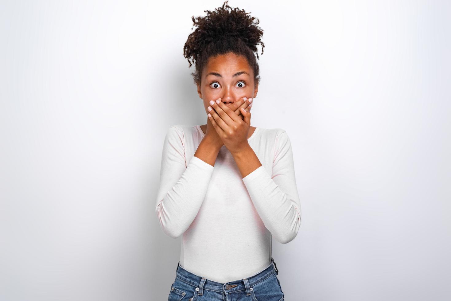 Shocked woman closed herself mouth by her hands and looking with horror . Concept image photo