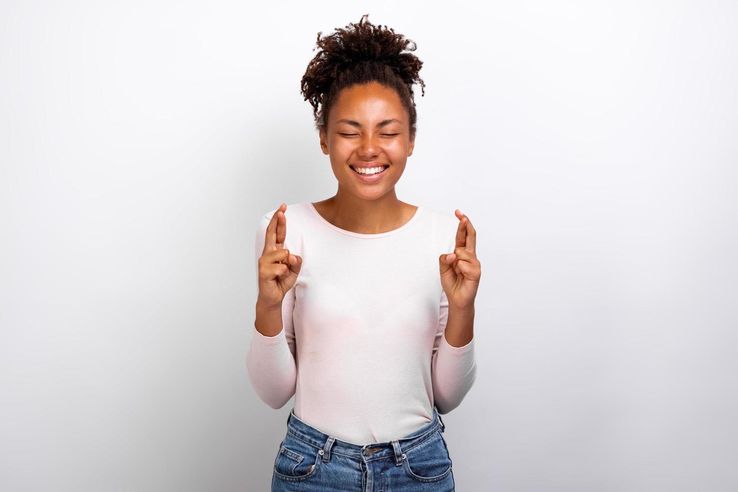 Cute woman crossing her fingers and wishing for good luck - Image photo