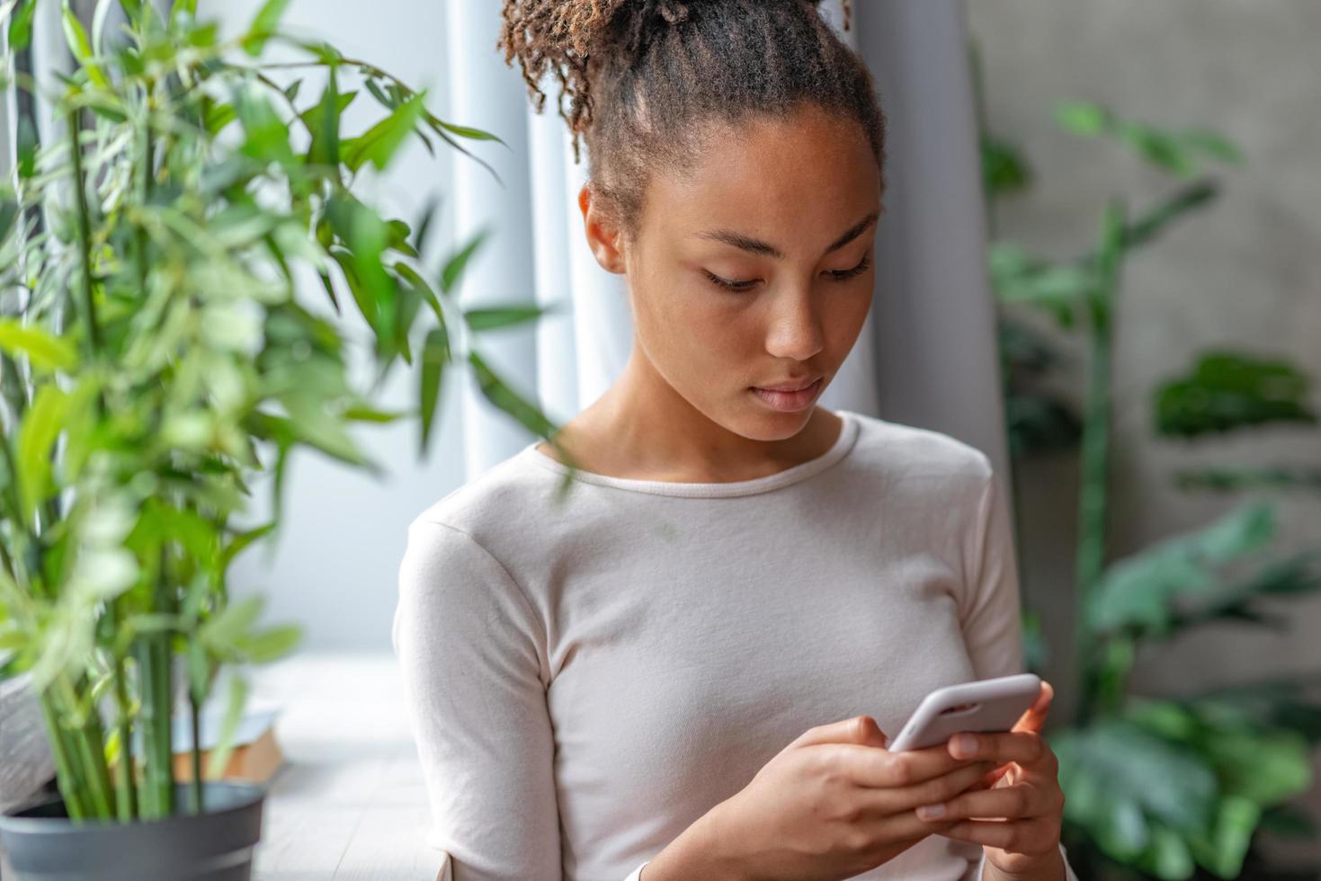 Woman holding a mobile phone looking at the screen and typing . - Image photo