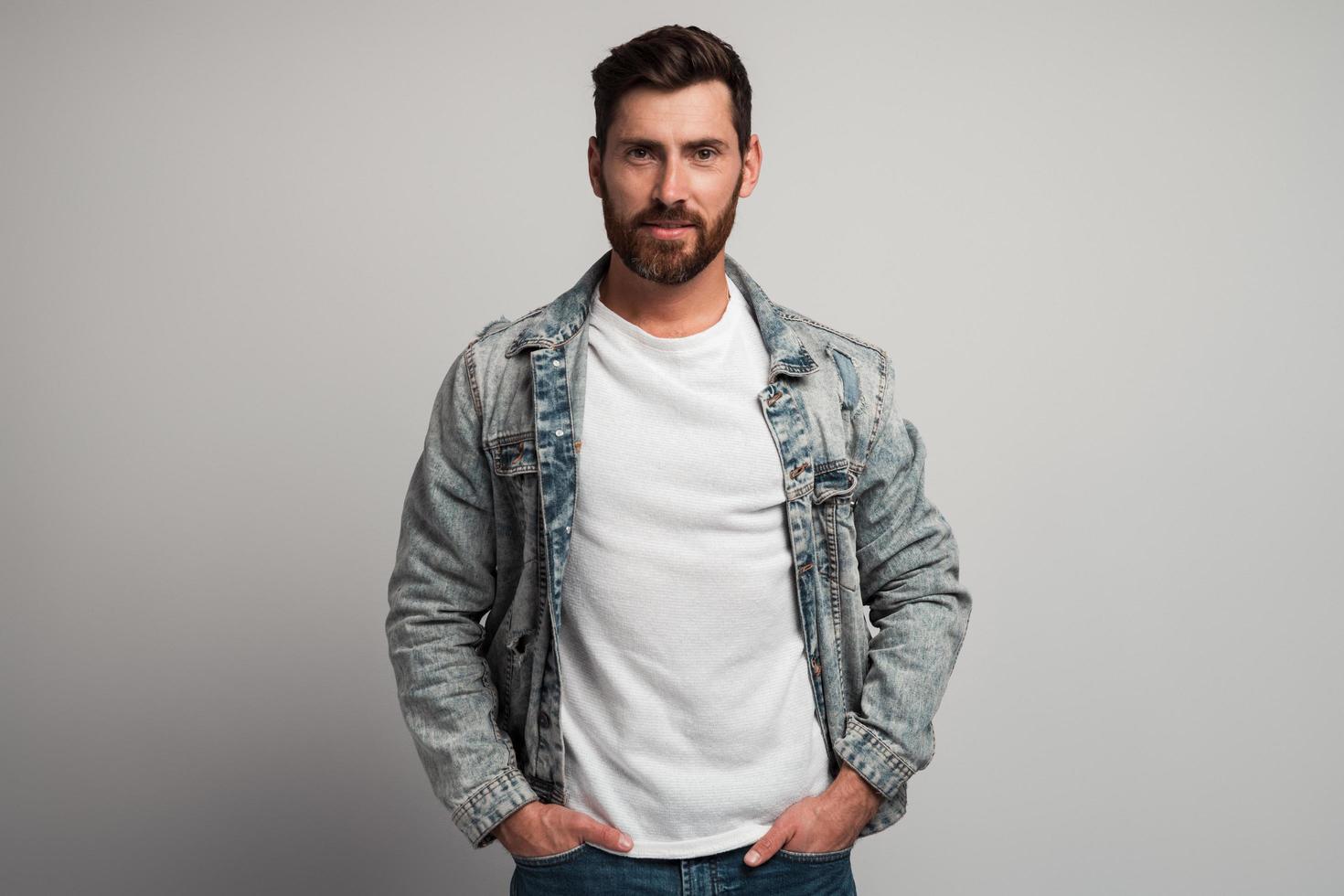 Portrait of attentive self confident bearded man looking at camera with serious expression. Smiling determined business man. Indoor studio shot isolated on white background photo